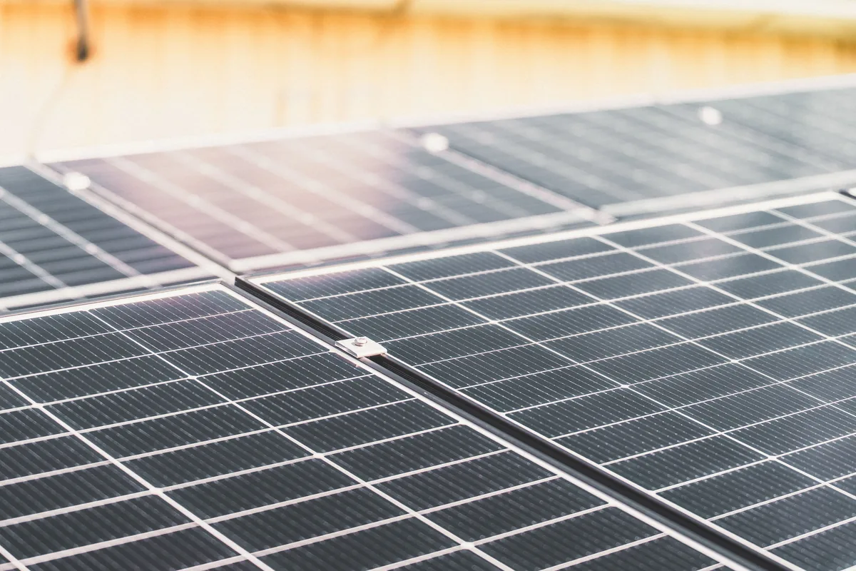 Rangées de panneaux photovoltaïques installés en toiture, exposés au soleil